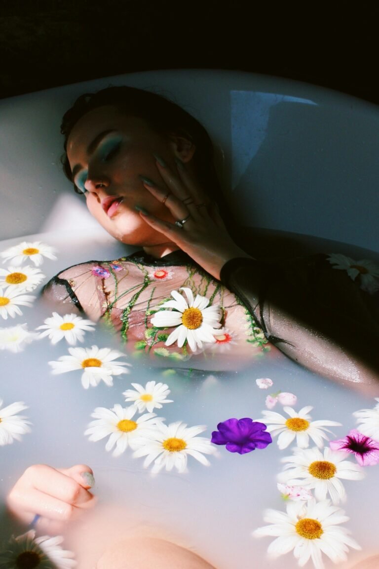Serene woman relaxing in a floral milk bath with daisies, promoting self-care.