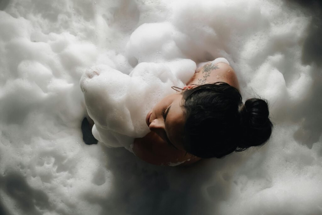 Top view of a woman relaxing in a foamy bathtub, embracing tranquility.