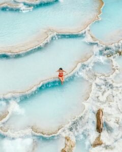 A woman enjoys a peaceful moment in Saturnia's stunning thermal baths, Tuscany, Italy.