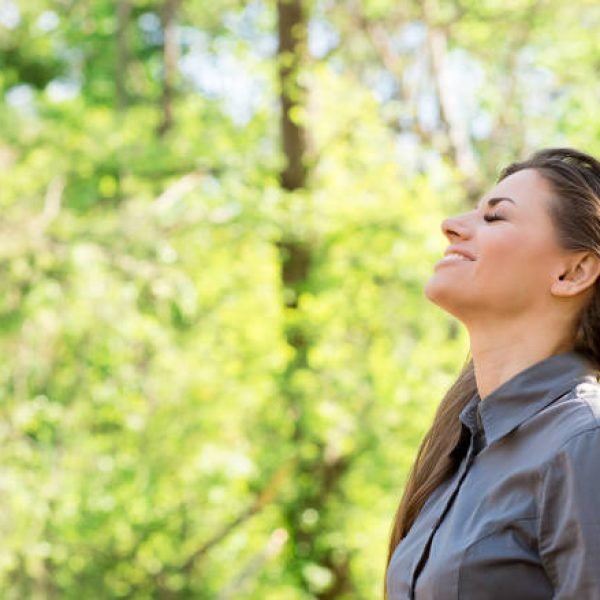 Side view of happy woman taking deep breath and closing eyes enjoying freedom and nature summer vacation