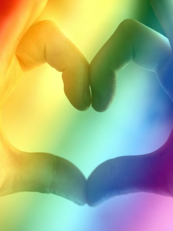 Hands forming a rainbow heart shape, symbolizing love, unity, and LGBTQ pride.